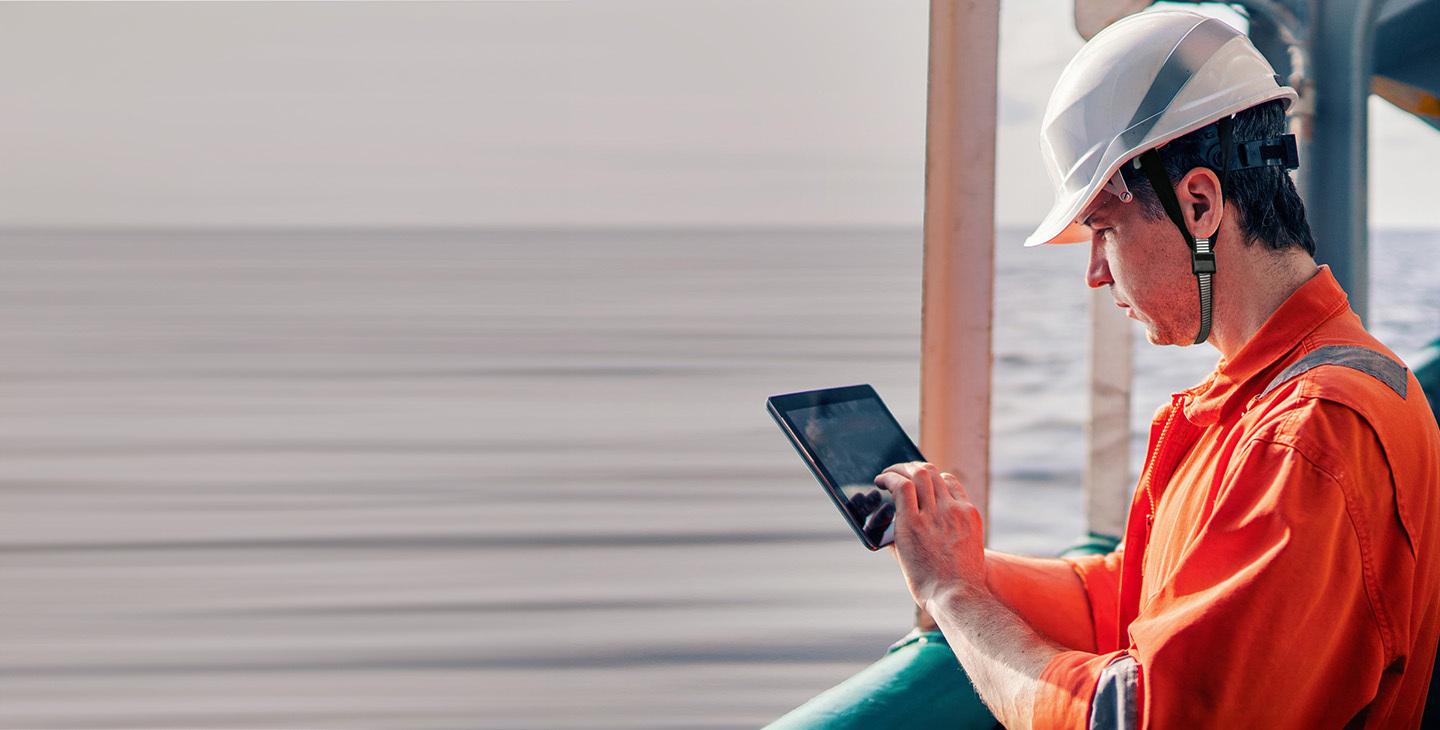 A man on a derrick at sea, using Viasat internet to improve safety for maritime workers